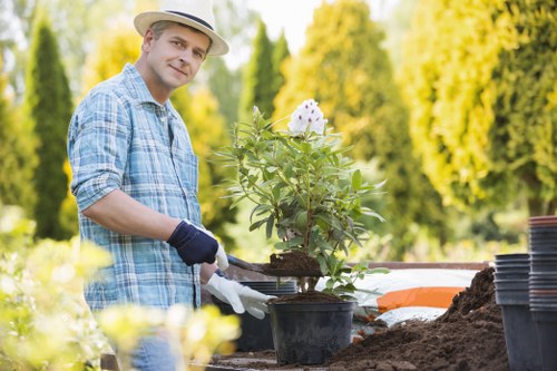 Gardener measuring a semi-detached back garden for a quote